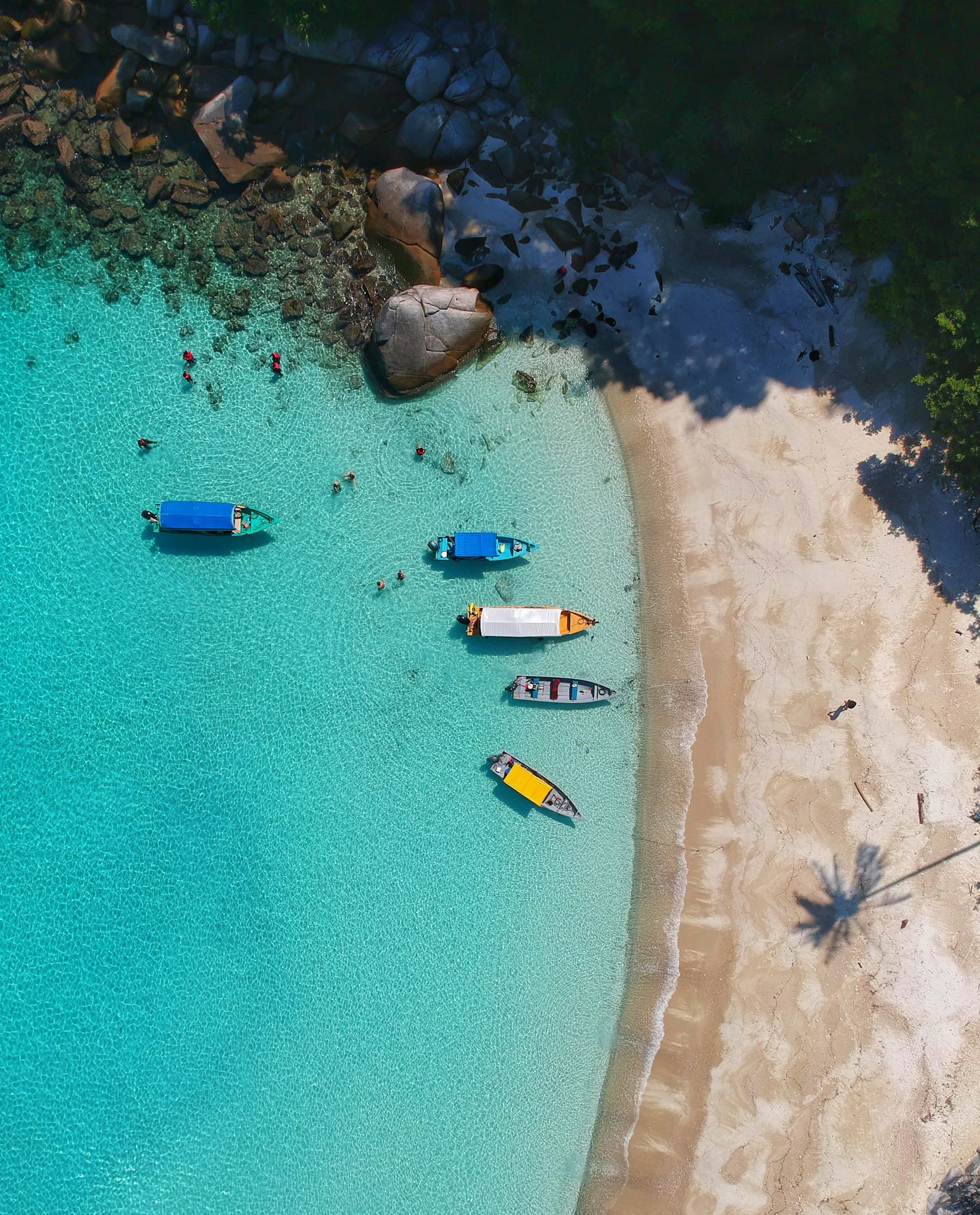 Aerial view of a Caribbean beach with boats in turquoise water