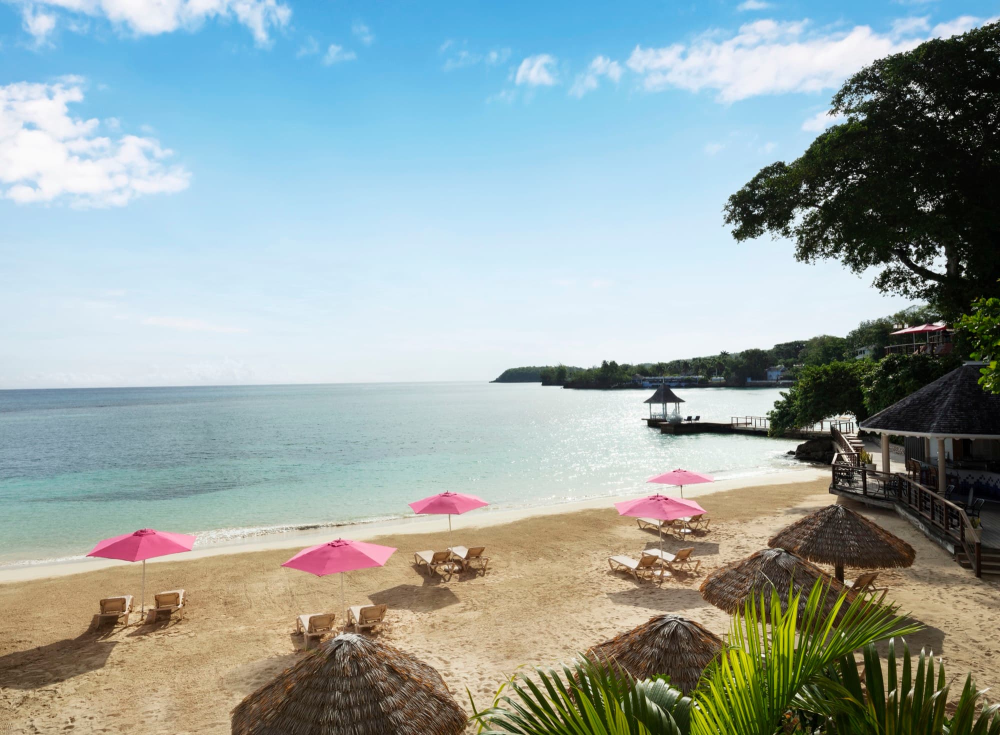 Pink umbrellas on the beach at Sandals Royal Plantation